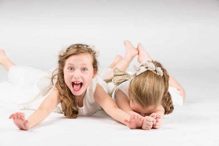 Fotografía de Comunión en Familia - Fotógrafo de Tarragona Fotografia de dos hermanas riendo para su reportaje de comunion en estudio, por el fotografo Juan Segovia en Tarragona