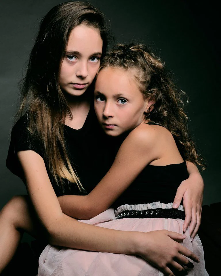 Fotografía de Comunión en Familia - Fotógrafo de Tarragona Fotografía de estudio para el reportaje en familia de dos hermanas, abrazadas, por el fotógrafo Juan Segovia en Tarragona
