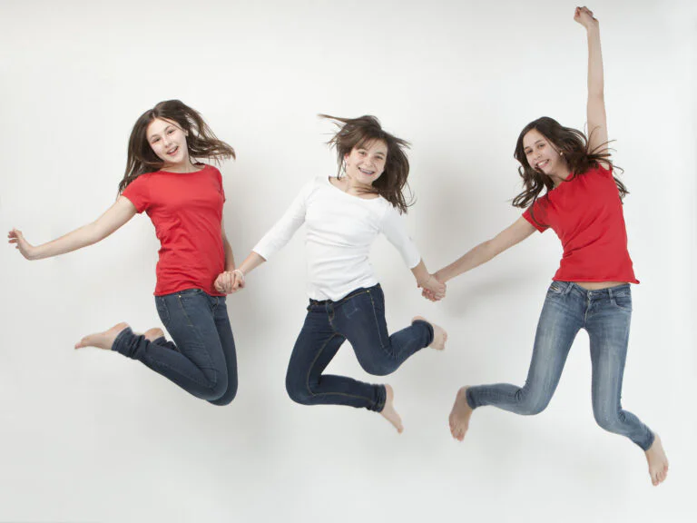 Fotografía de Familia - Fotógrafo de Tarragona Fotografía profesional en Tarragona de familia en estudio de tres hermanas saltando.