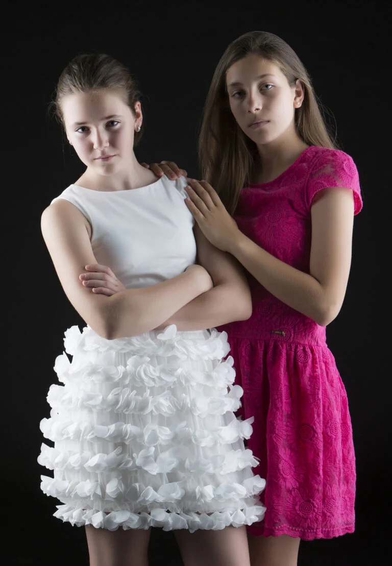 Fotografía de Familia - Fotógrafo de Tarragona Fotografía en estudio de dos primas posando con vestido blanco y vestido rosa. Fotografía de familia por Juan Segovia, fotógrafo en Tarragona