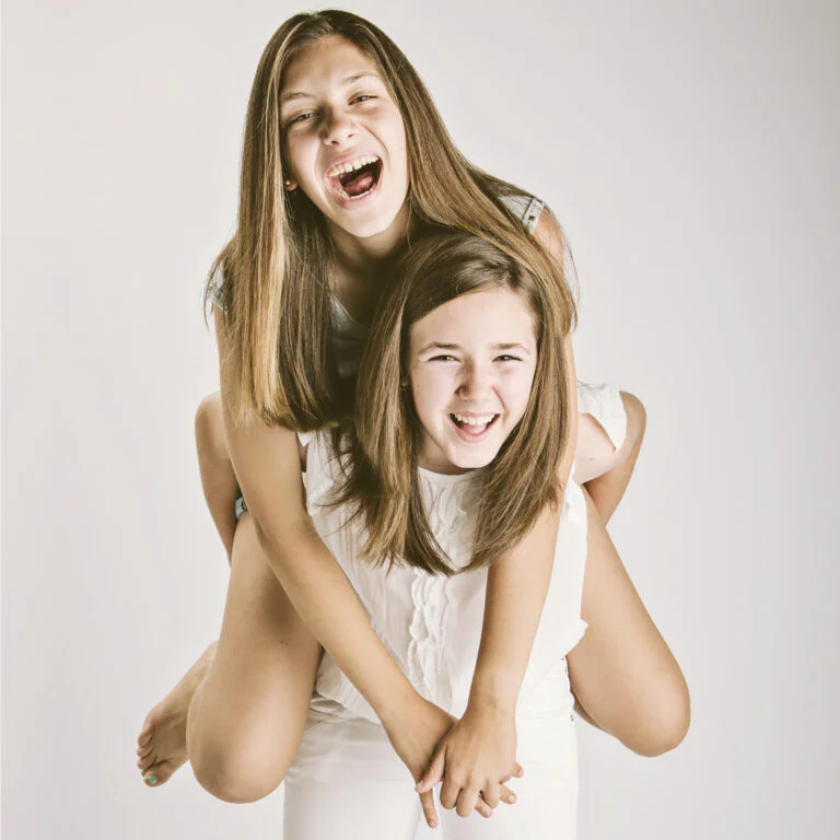 Fotografía de Familia - Fotógrafo de Tarragona Dos hermanas sonriendo, Fotografía de familia en estudio. Juan Segovia, fotógrafo Tarragona