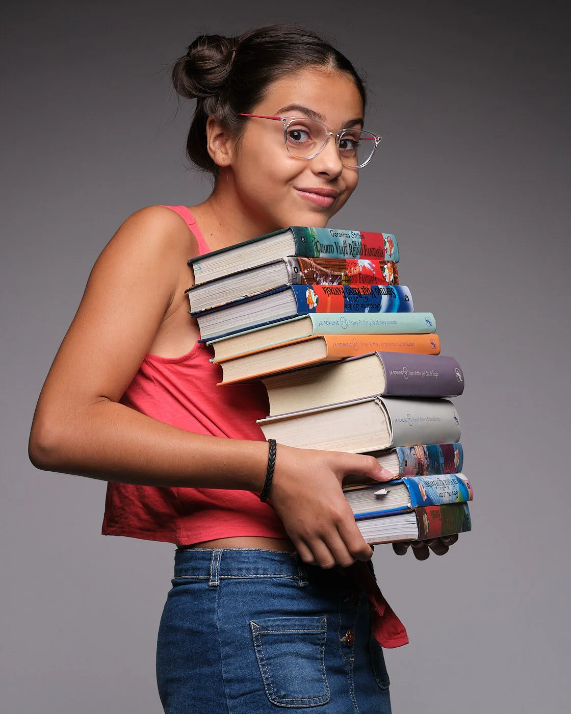 Fotografia Jasmine Serra con libros Fotografia de Jasmine Serra con gafas sonriendo y sujetando una pila de libros