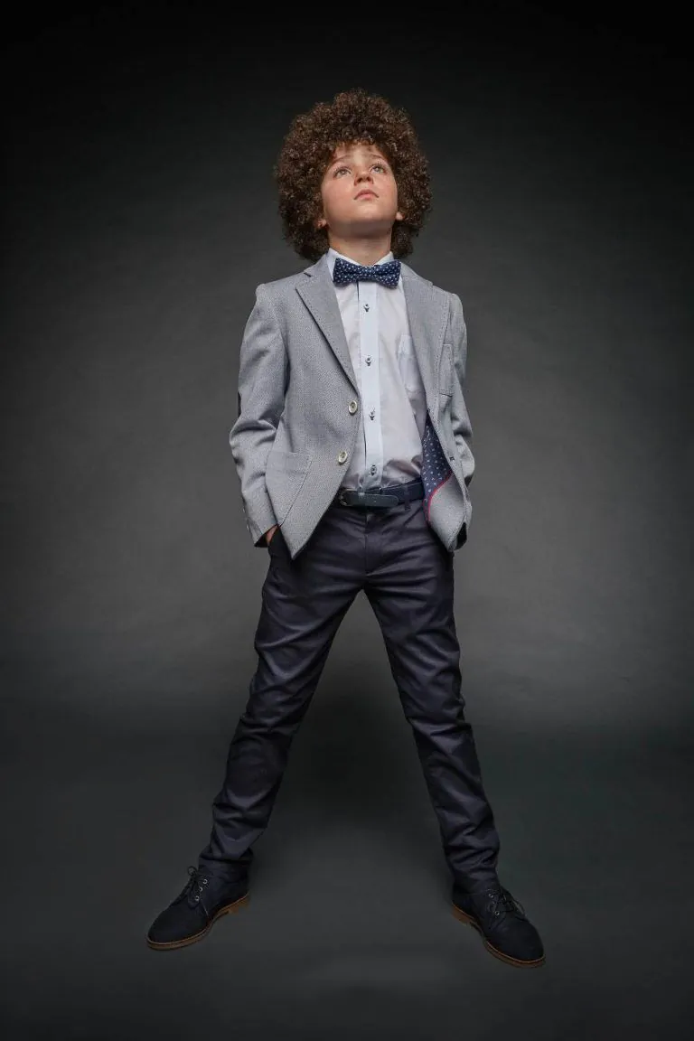Galería de Fotos de Niños de Comunión en Estudio - Fotógrafo de Tarragona Fotografia de Max con pelo afro mirando hacia arriba para su reportaje de comunion en el estudio de Juan Segovia en Tarragona