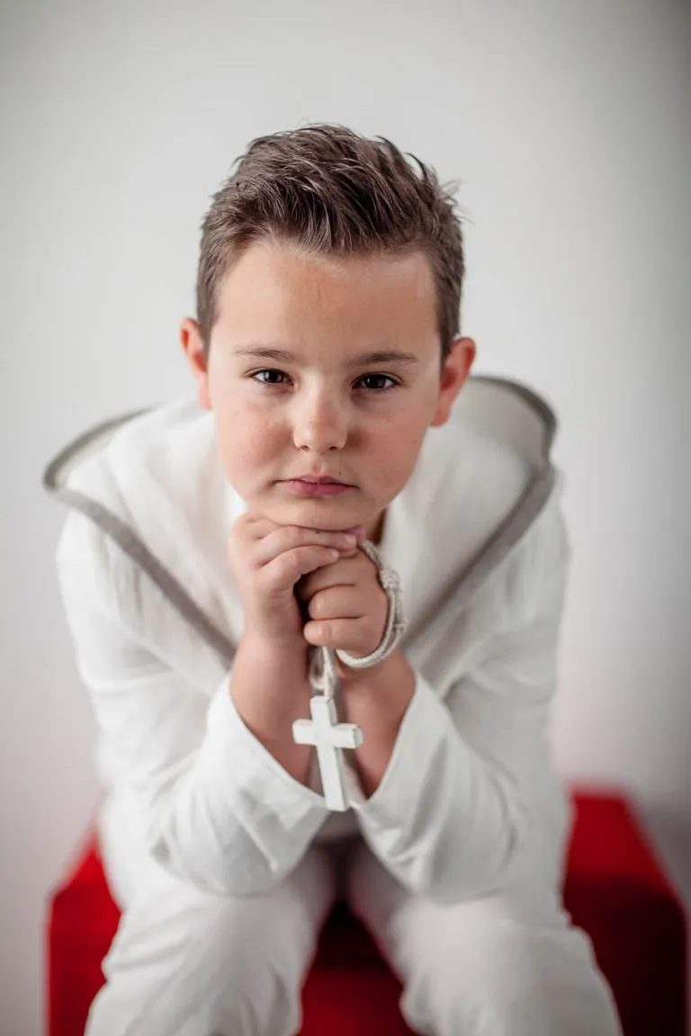 Galería de Fotos de Niños de Comunión en Estudio - Fotógrafo de Tarragona Fotografia de un nino con crucifijo para su reportaje de comunion en el estudio de Juan Segovia en Tarragona