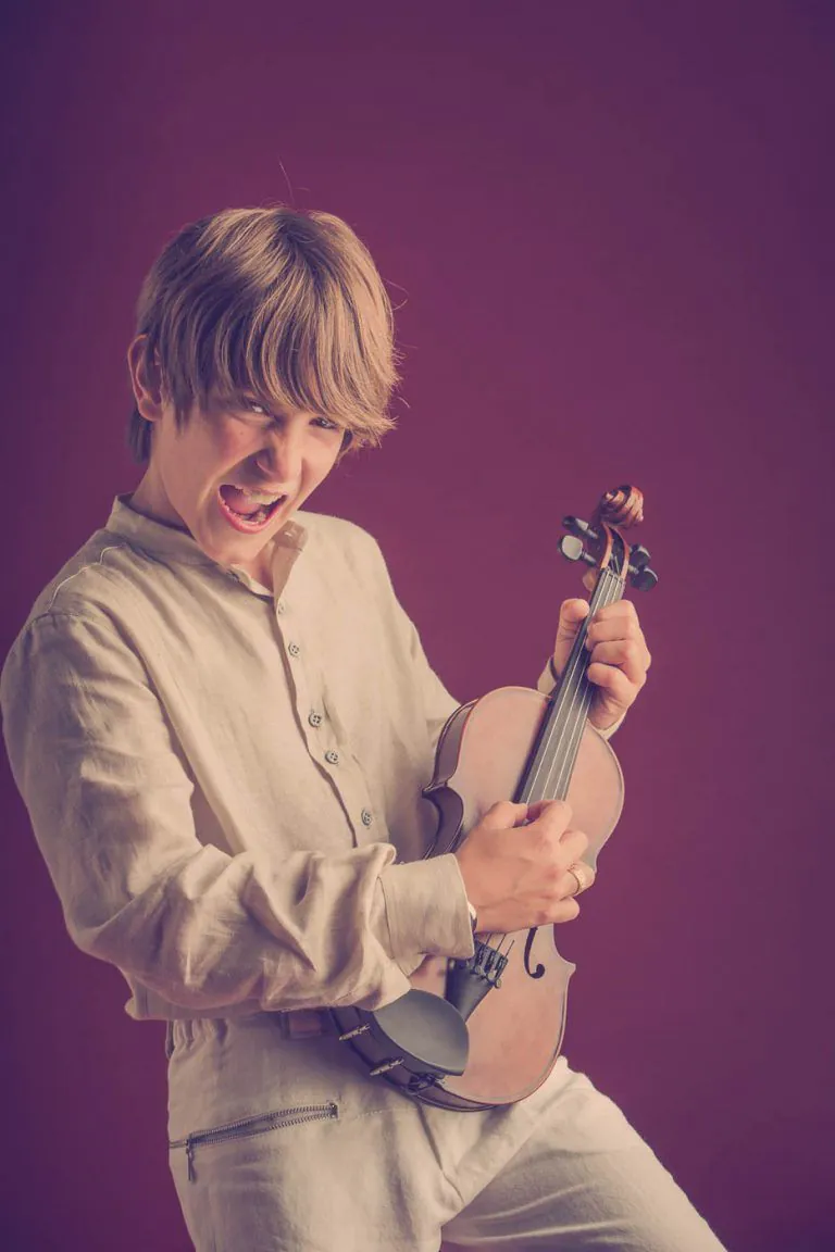 Galería de Fotos de Niños de Comunión en Estudio - Fotógrafo de Tarragona Fotografia de un nino con su violin como guitarra para su reportaje de comunion en el estudio de Juan Segovia en Tarragona