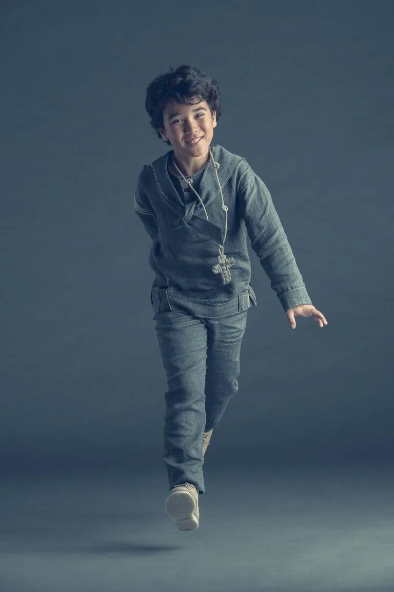 Galería de Fotos de Niños de Comunión en Estudio - Fotógrafo de Tarragona Fotografia de un nino con traje de marinero saltando para su reportaje de comunion en el estudio de Juan Segovia en Tarragona