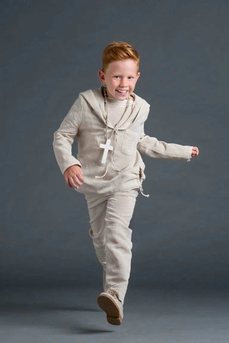Galería de Fotos de Niños de Comunión en Estudio - Fotógrafo de Tarragona Fotografia de un nino pelirojo corriendo para su reportaje de comunion en el estudio de Juan Segovia en Tarragona