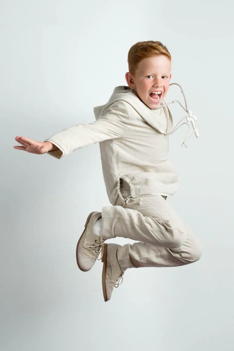 Galería de Fotos de Niños de Comunión en Estudio - Fotógrafo de Tarragona Fotografia de un nino pelirojo saltando para su reportaje de comunion en el estudio de Juan Segovia en Tarragona