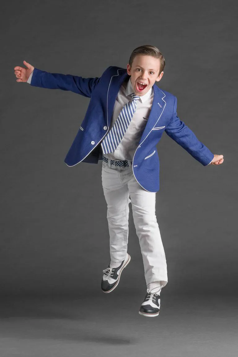 Galería de Fotos de Niños de Comunión en Estudio - Fotógrafo de Tarragona Fotografia de un nino repeinado con americana azul gritando para su reportaje de comunion en el estudio de Juan Segovia en Tarragona