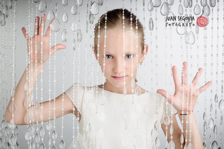 Galería de Fotos de Niñas de Comunión en Estudio - Fotógrafo de Tarragona Fotografía de una niña a través de una cortina para su reportaje fotos de niñas de comunión en estudio del fotógrafo Juan Segovia en Tarragona