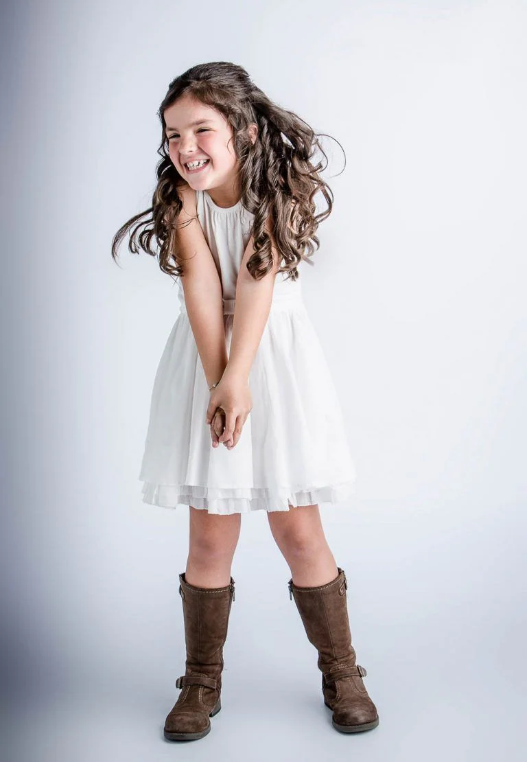 Galería de Fotos de Niñas de Comunión en Estudio - Fotógrafo de Tarragona Fotografia de una nina con botas para su reportaje de comunion en el estudio del fotografo Juan Segovia en Tarragona