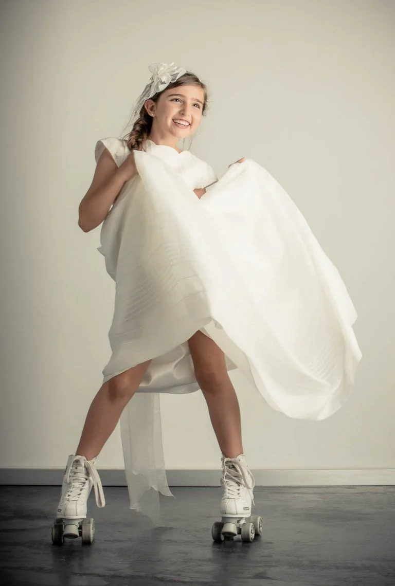 Galería de Fotos de Niñas de Comunión en Estudio - Fotógrafo de Tarragona Fotografia de una nina con patines y vestido arremangado para su reportaje de comunion en el estudio del fotografo Juan Segovia en Tarragona