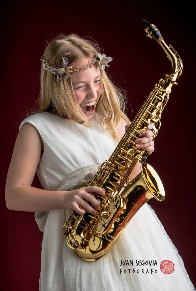 Galería de Fotos de Niñas de Comunión en Estudio - Fotógrafo de Tarragona Fotografia de una nina con su saxo para su reportaje de comunion en el estudio del fotografo Juan Segovia en Tarragona