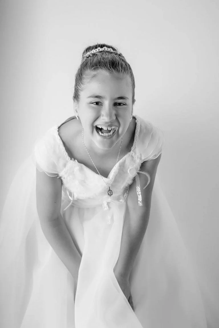 Galería de Fotos de Niñas de Comunión en Estudio - Fotógrafo de Tarragona Fotografia de una nina partiendose de risa para su reportaje de comunion en el estudio del fotografo Juan Segovia en Tarragona
