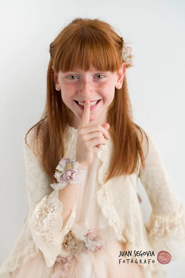 Galería de Fotos de Niñas de Comunión en Estudio - Fotógrafo de Tarragona Fotografia de una nina peliroja sonriente para su reportaje de comunion en el estudio del fotografo Juan Segovia en Tarragona
