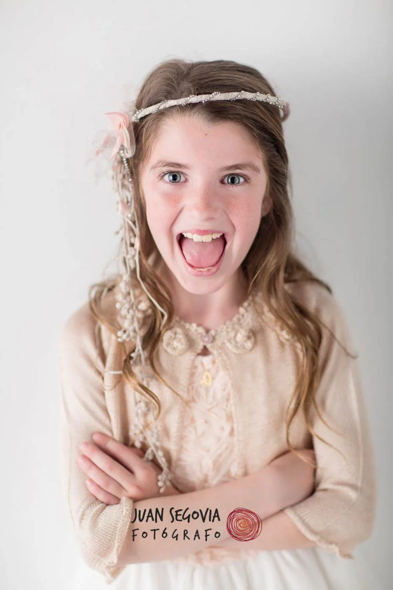 Galería de Fotos de Niñas de Comunión en Estudio - Fotógrafo de Tarragona Fotografia de una nina sacando la lengua para su reportaje de comunion en el estudio del fotografo Juan Segovia en Tarragona